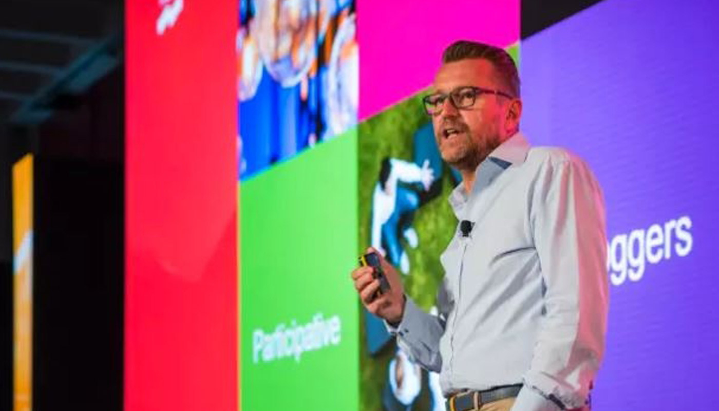 Ian Cummings presenting on a stage at an event