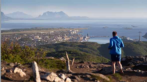 Hiker on a mountain with view over Bodo